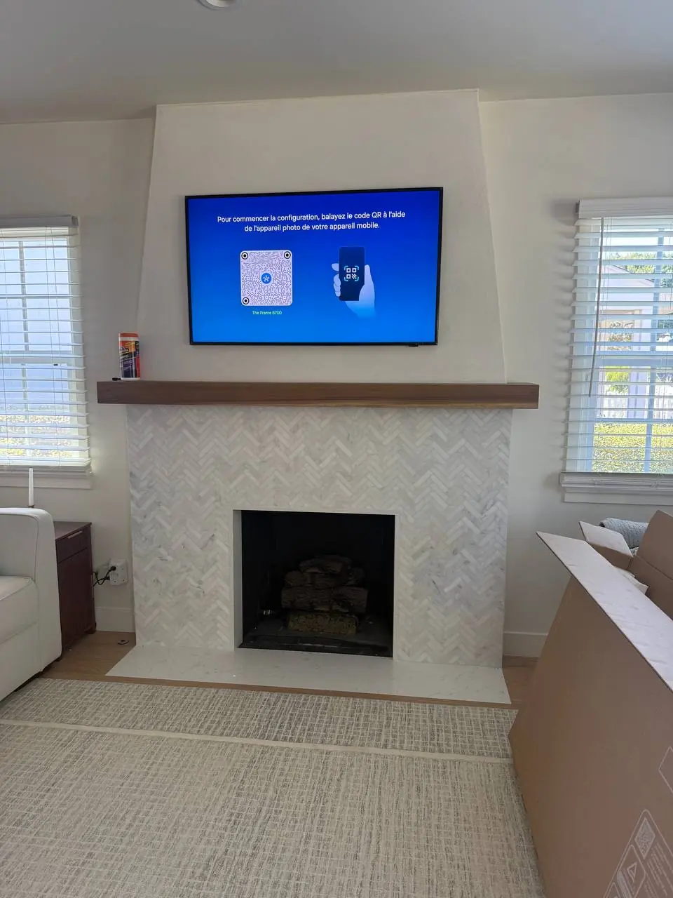 Television mounted above a fireplace in a bright living room
